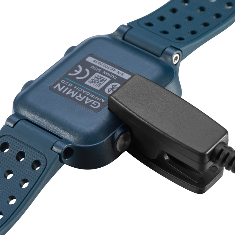 Blue Garmin smartwatch with black charging clip dock attached
