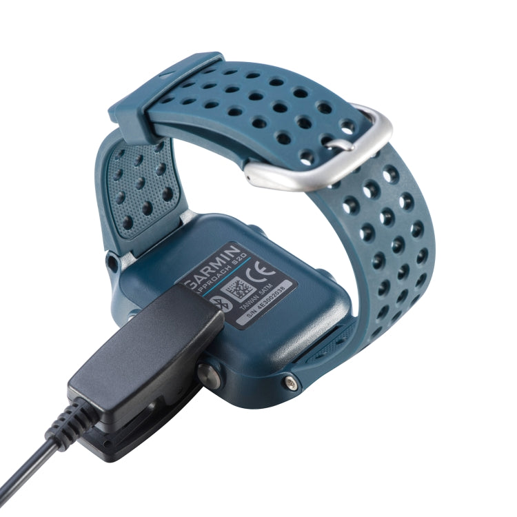 Blue Garmin smartwatch with perforated band and black USB charging clip dock
