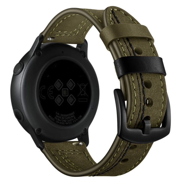 Olive green leather watch strap with blue stitching and metal buckle, with dark watch case