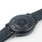 Close-up: magnetic charger puck on the back of a black smartwatch