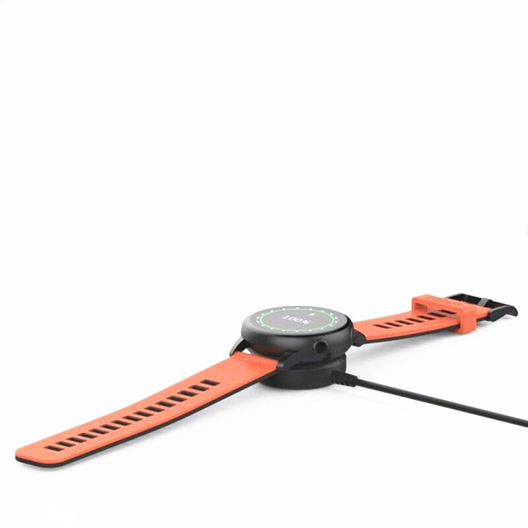 Magnetic watch charger dock attached to orange smartwatch band with black cable