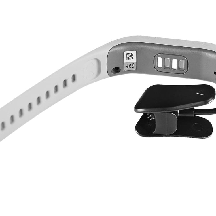 Side view of smartwatch charging contacts with black clip dock and band
