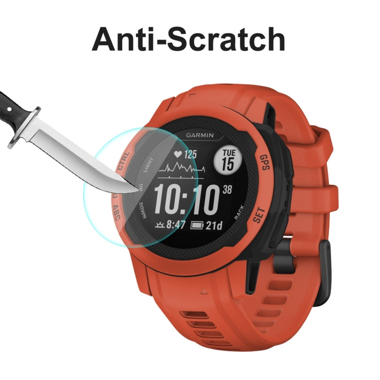 Anti-scratch tempered glass screen protector on orange Garmin smartwatch, scratch test tool
