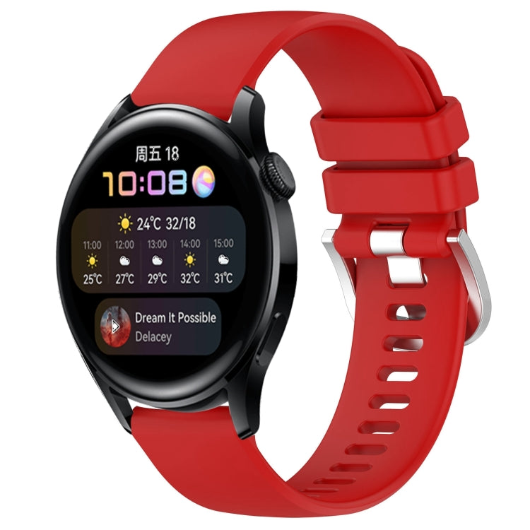 Red silicone watch band with glossy buckle and perforated strap, smartwatch attached