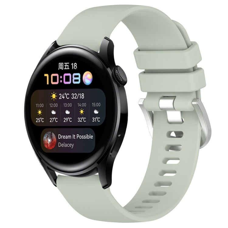 Mint green silicone watch band with glossy buckle and perforated strap, smartwatch attached