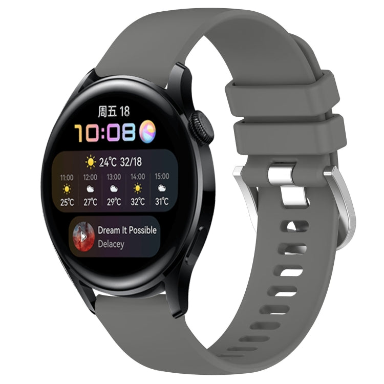 Dark gray silicone watch band with glossy buckle and perforated strap, smartwatch attached