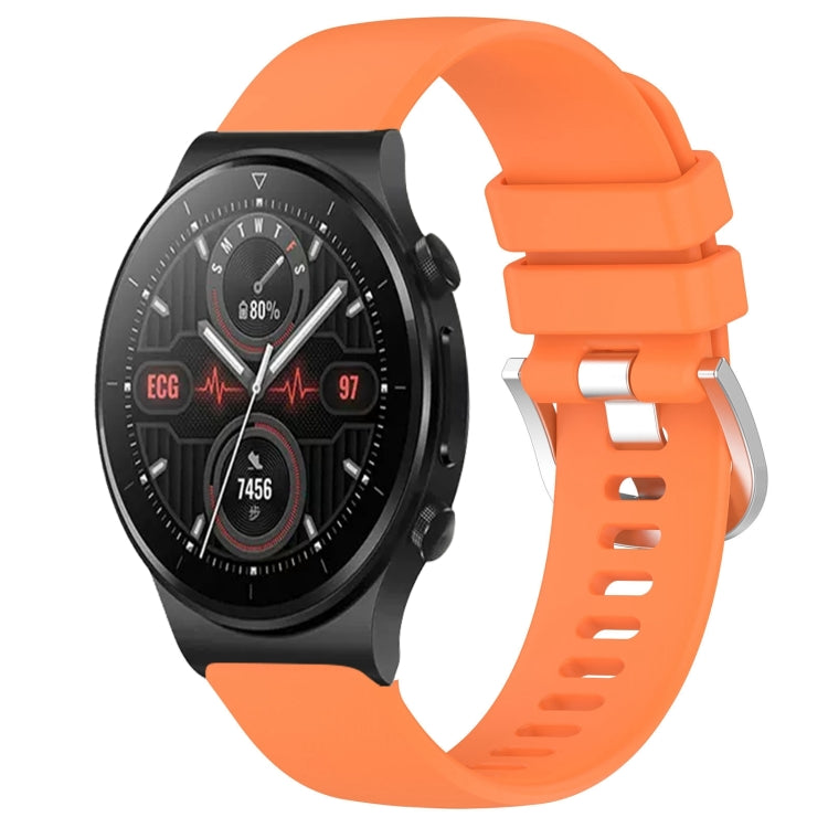 Orange silicone watch band with glossy buckle and perforated strap, smartwatch attached