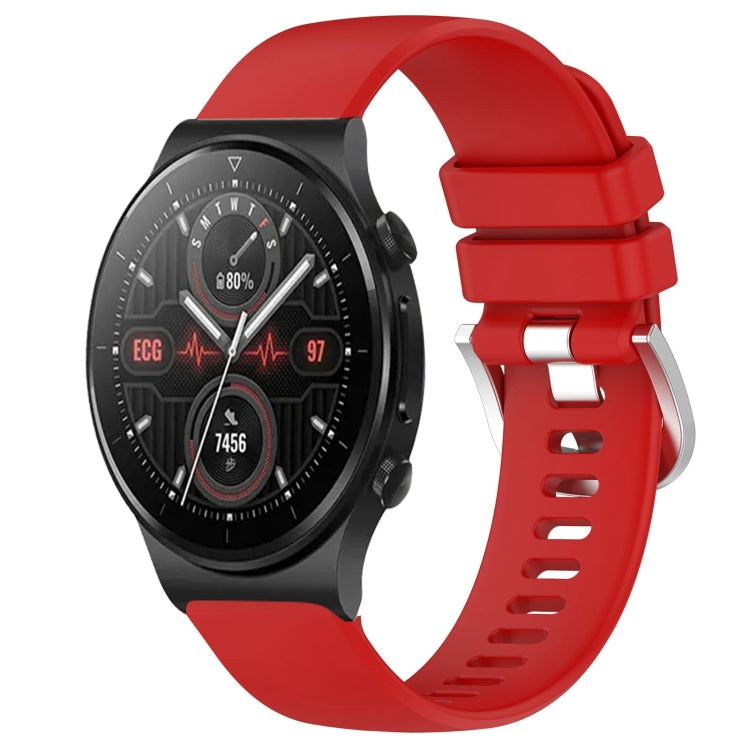 Red silicone watch band with glossy buckle and perforated strap, smartwatch attached