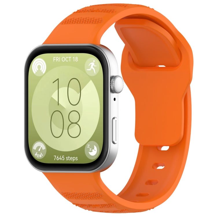 Orange silicone sports watch band with textured grip sections, shown attached to a smartwatch.