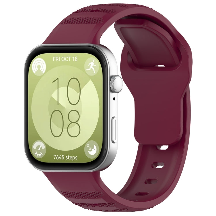 Wine red silicone sports watch band with textured grip sections, shown attached to a smartwatch.