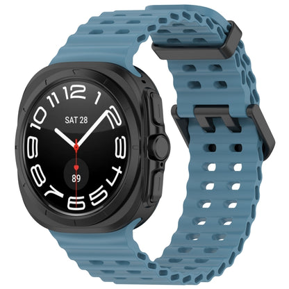 Blue silicone watch band with ventilated holes and dual buckle, shown on a smartwatch