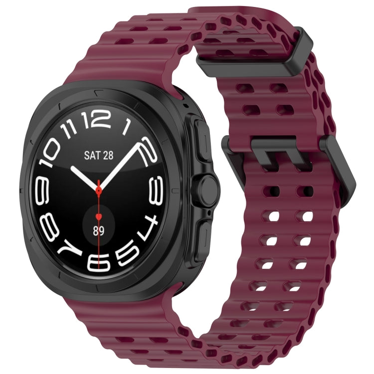 Wine red silicone watch band with ventilated holes and dual buckle, shown on a smartwatch
