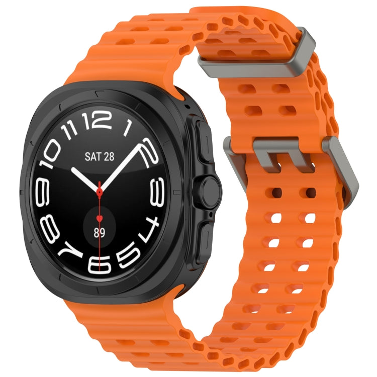 Orange perforated silicone watch band with dual buckle on a black smartwatch