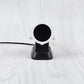 Round magnetic charging dock with black contact plate and white strap