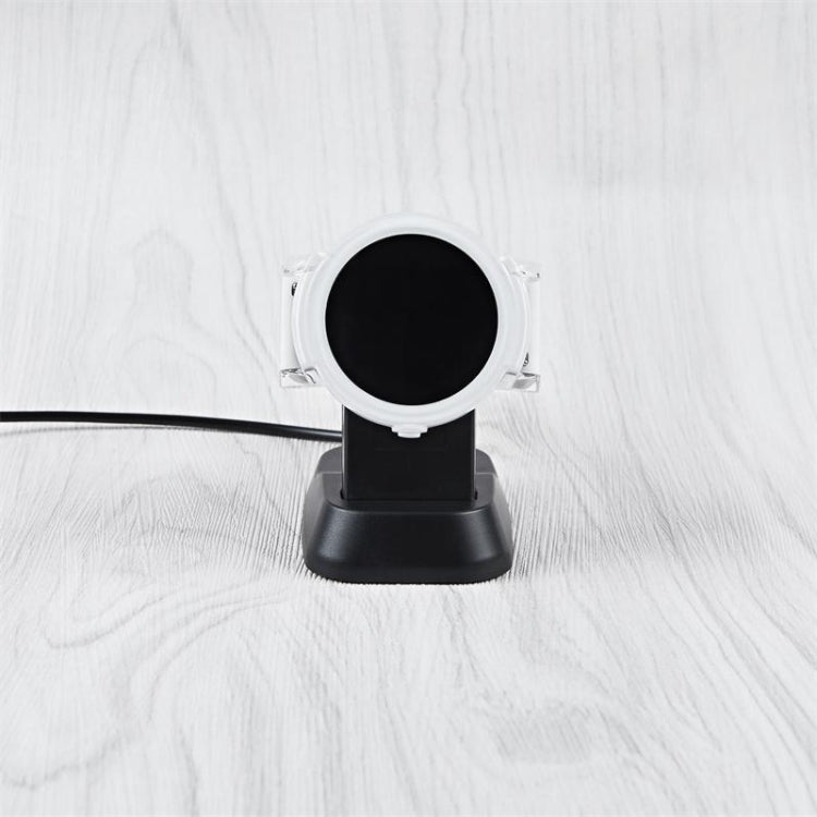 Round magnetic charging dock with black contact plate and white strap
