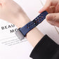 Navy perforated silicone watch band fastened around a wrist