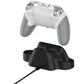 White game controller resting on black charging dock base with charging cable