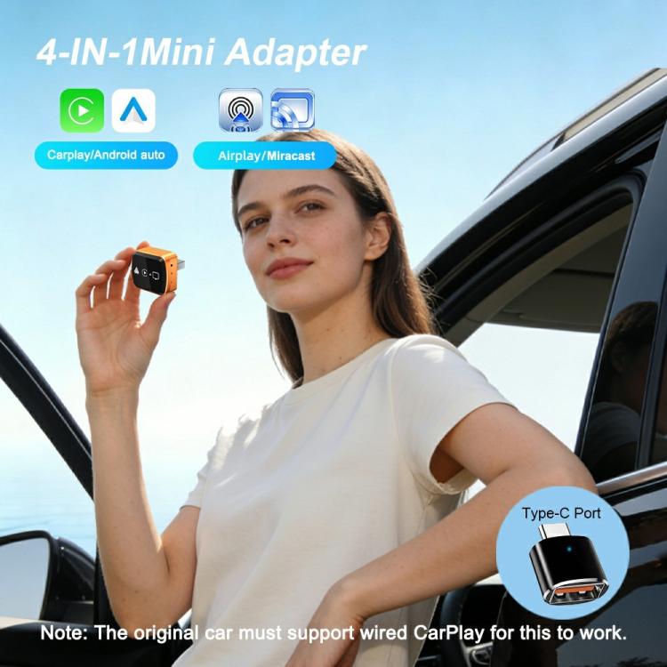 Orange and black screen mirroring adapter held in hand, USB plug visible