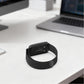 Black metal mesh watch band looped around a watch back