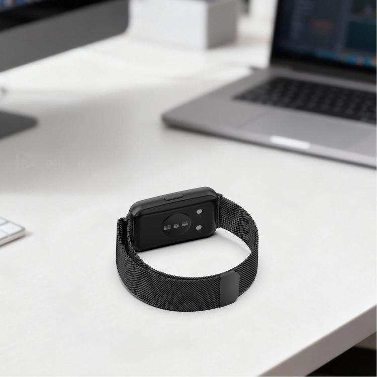 Black metal mesh watch band looped around a watch back