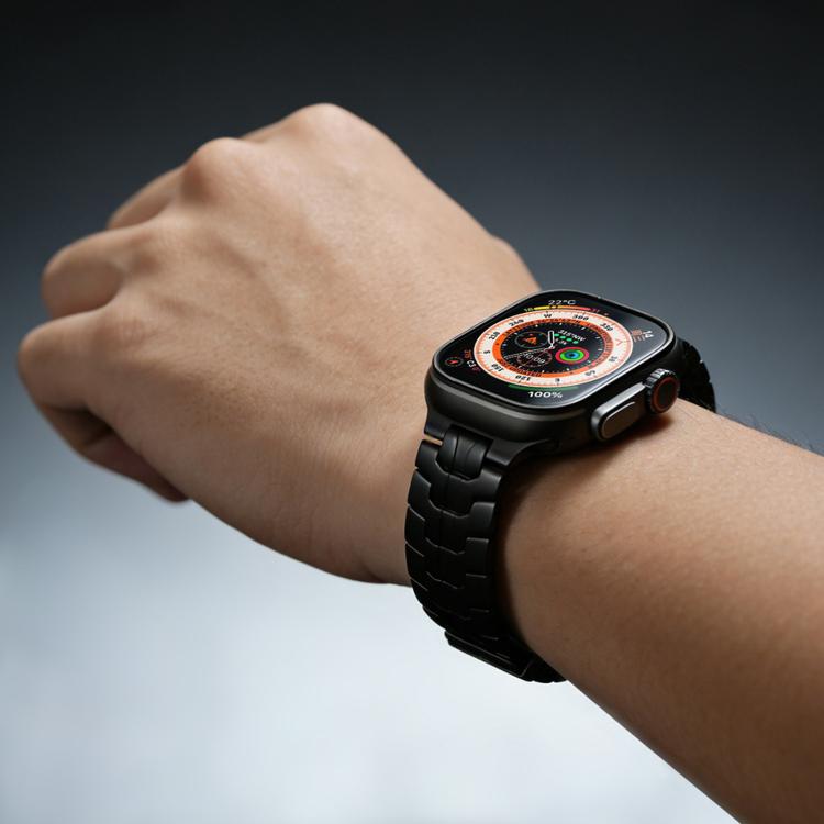 Black metal watch band worn on a wrist, attached to a smartwatch.