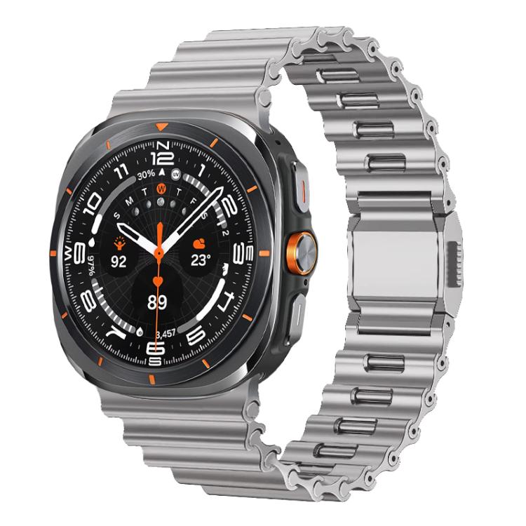 Silver stainless steel watch band with wave-textured links and folding clasp, shown on a smartwatch
