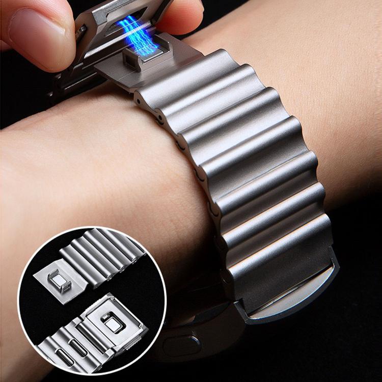 Silver wave-textured watch band worn on a wrist, with magnetic clasp detail