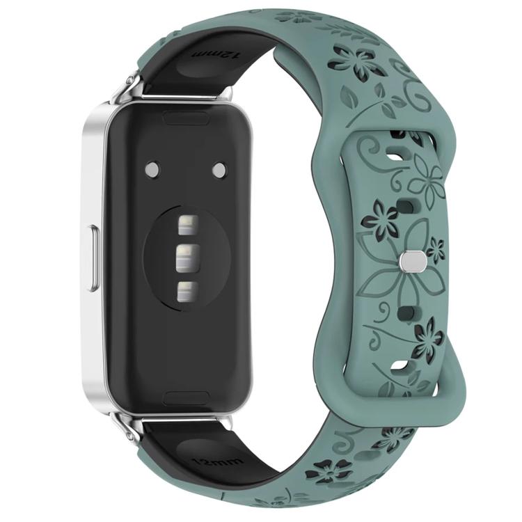 Teal and black floral watch band with a reverse buckle, shown on a watch