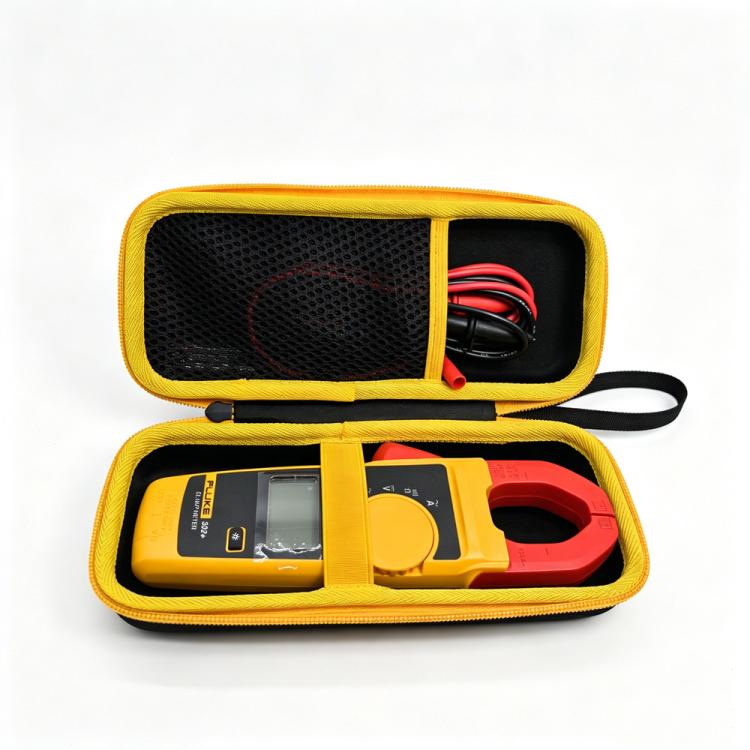 Hard clamp meter case, black with yellow trim, holding meter and red test leads.