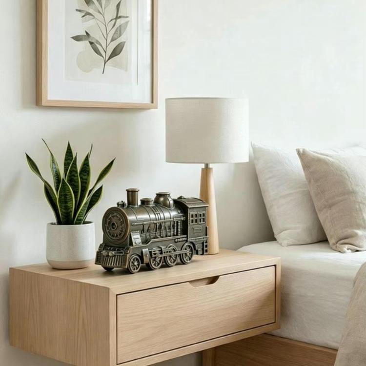 Gray train-shaped desktop humidifier on a bedside table with visible mist