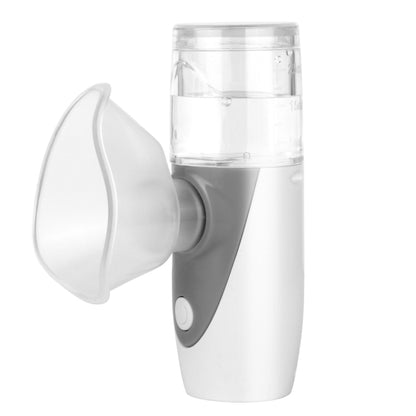 Handheld white mesh nebulizer with clear medicine cup and mouthpiece, gray grip