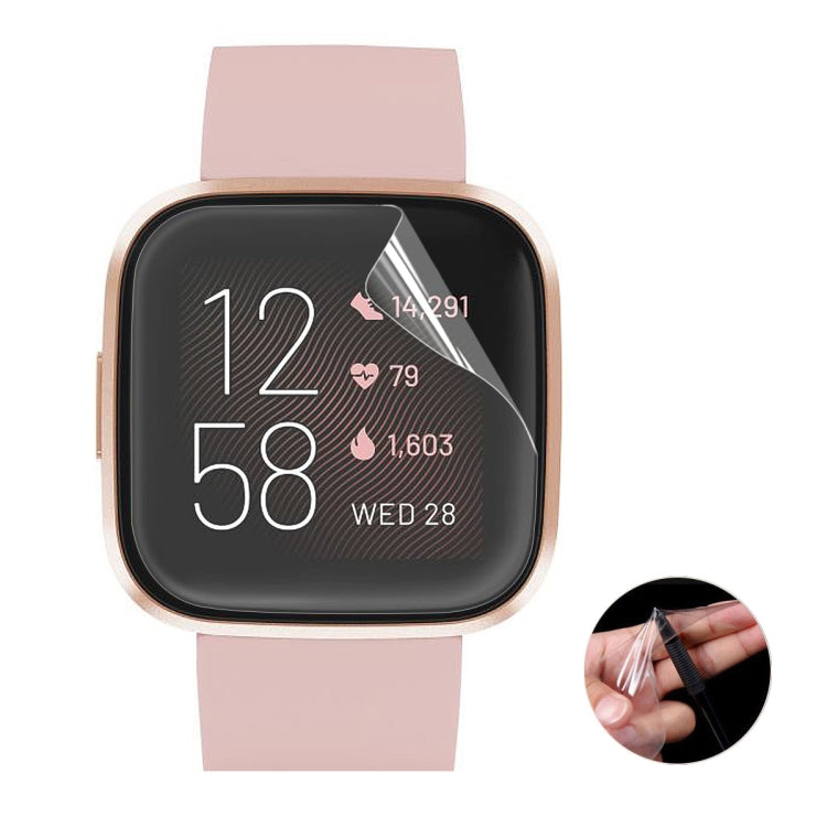 TPU screen protector film covering Fitbit watch face on pink strap, aligned edges