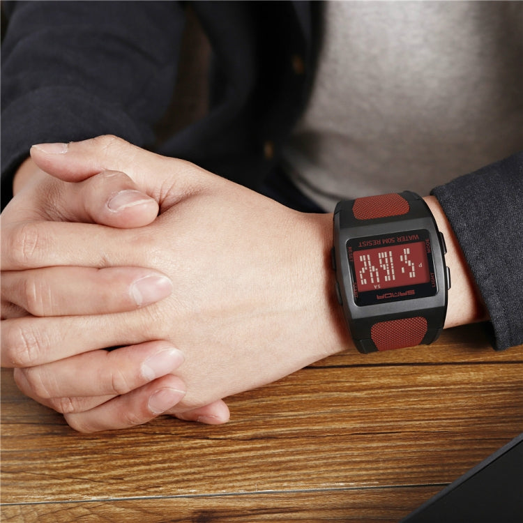 Red-and-black digital sports watch on wrist with square LCD display