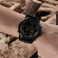 Multifunction digital wrist watch on wrist with black bezel, glowing screen, perforated strap