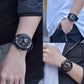 Black digital sports watch on wrist, round dial with red and blue details, textured strap