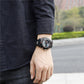Men's black waterproof sports watch on wrist, round bezel with digital display