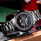 Men's analog watch on steel bracelet with black dial and red-accent wheel design