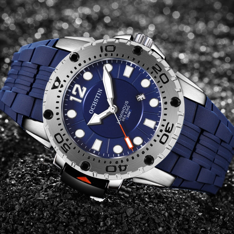 Close-up sports watch with blue dial, thick rugged bezel, and blue silicone link strap.