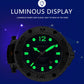 Blue dial sports watch showing luminous green hands and scales on dark bezel.