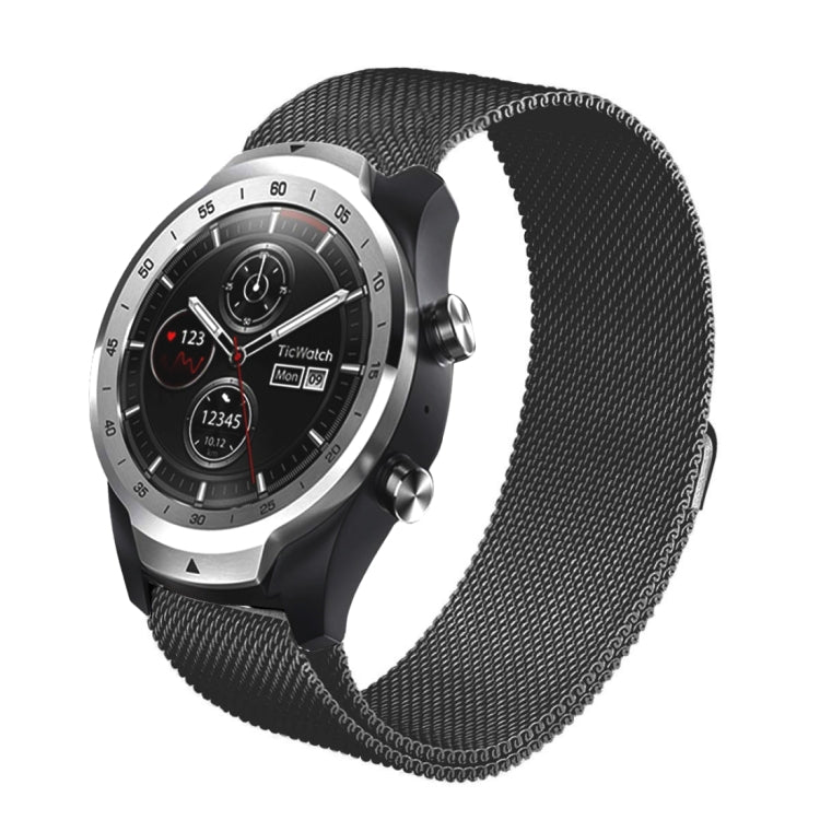 Black milanese metal watch strap with mesh links and magnetic-style clasp, worn on watch.