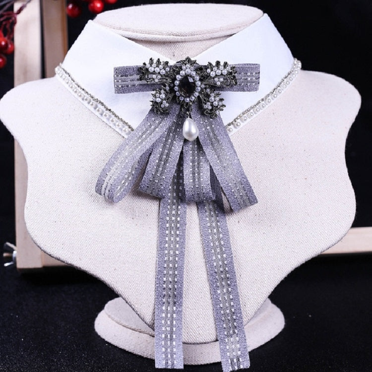 White shirt collar with light gray-blue striped bow tie and rhinestone pearl centerpiece