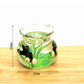 Miniature transparent glass fish tank with green plants and black fish