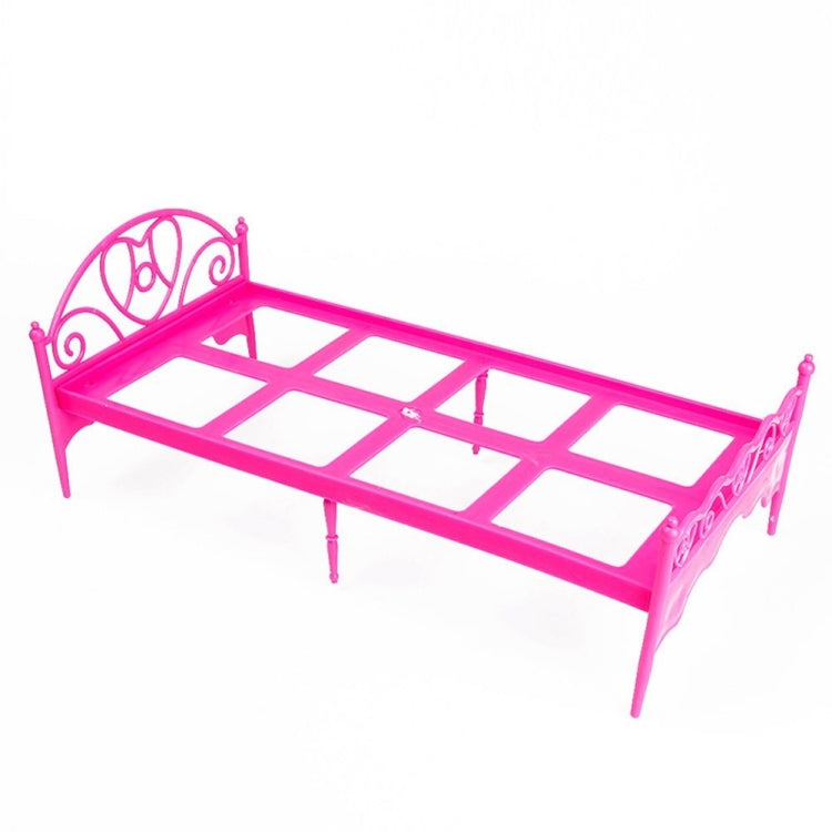 Mini pink plastic doll bed frame with decorative scroll headboard and slatted base