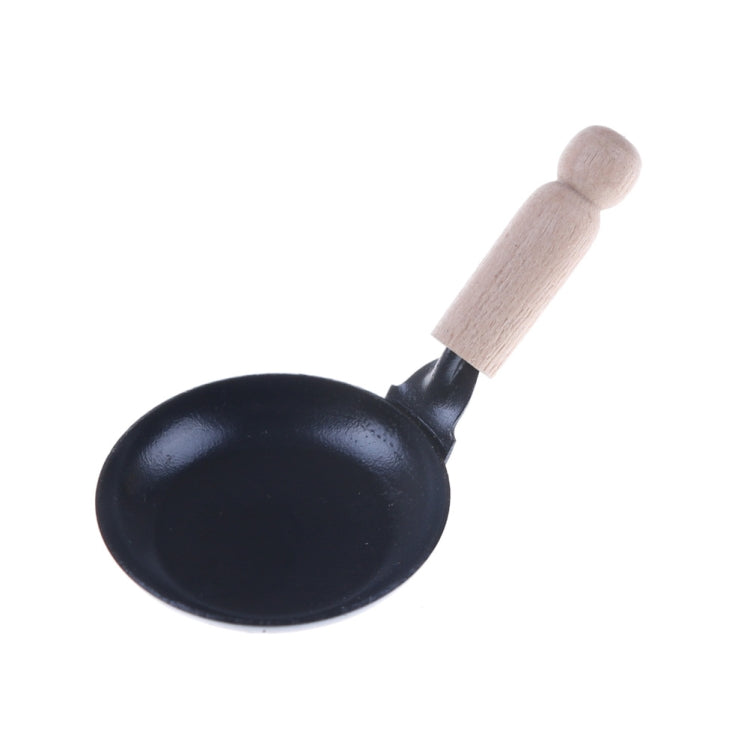 Miniature black frying pan with wooden handle, angled
