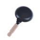 Miniature black frying pan with wooden handle, close-up side view