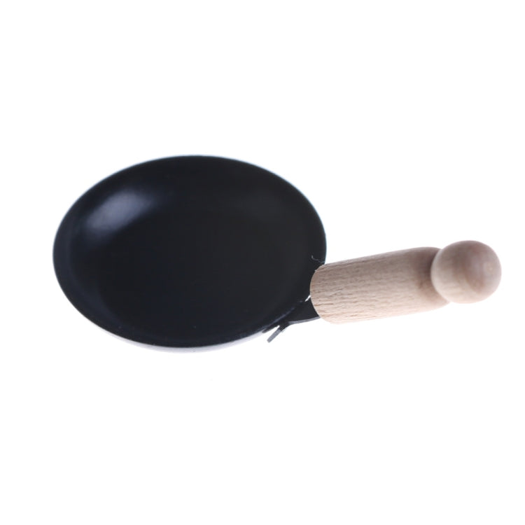 Miniature black frying pan with wooden handle, side view