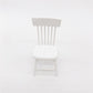 Miniature white dollhouse chair with slatted back and rounded seat.