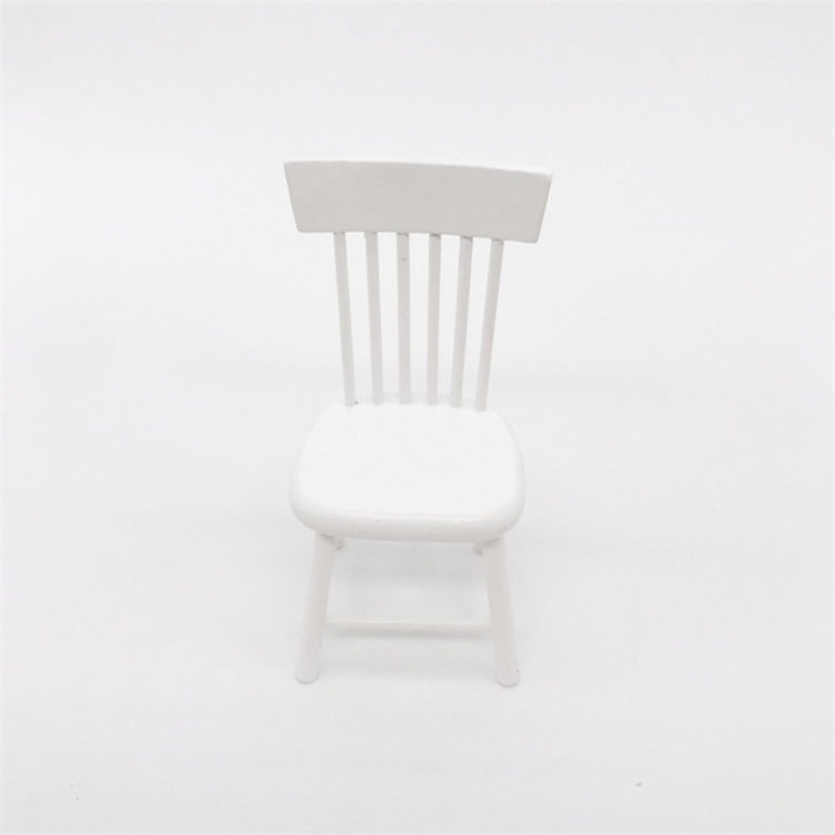 Miniature white dollhouse chair with slatted back and rounded seat.