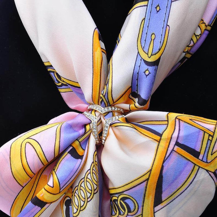 Crystal heart buckle brooch at scarf knot on patterned scarf
