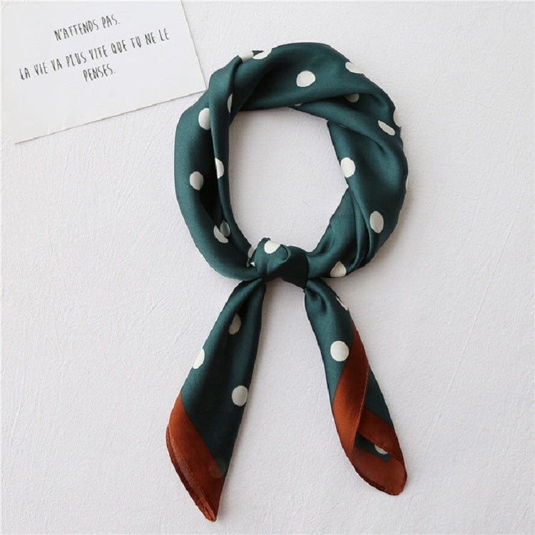 Dark green silk square scarf with white polka dots, draped around the neck